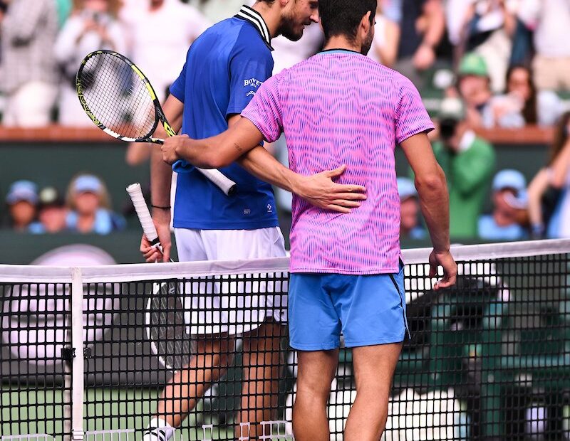 Alcaraz and Medvedv meeting at the net